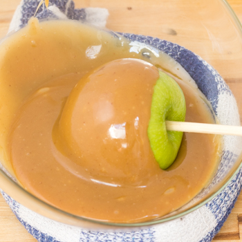 dipping the apple in caramel