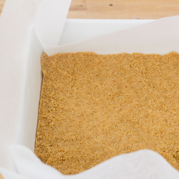 Graham cracker crust pressed into parchment lined pan.