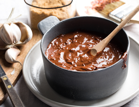  A pot of chocolate barbecue sauce with a wooden stirring spoon