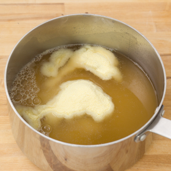 Stock in a pot with polenta and margarine added.