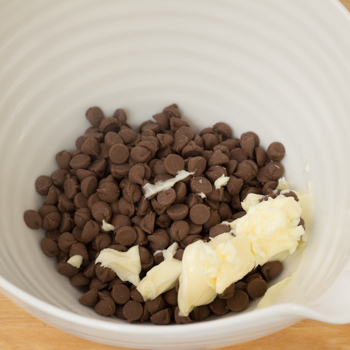 Chocolate chips and margarine in a bowl.